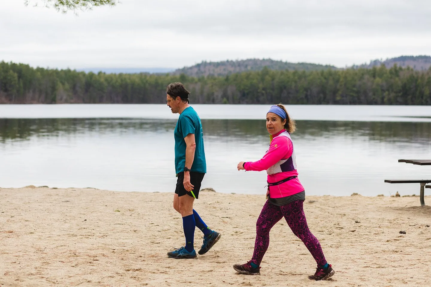 Runners on the beach with the mountains across White Lake