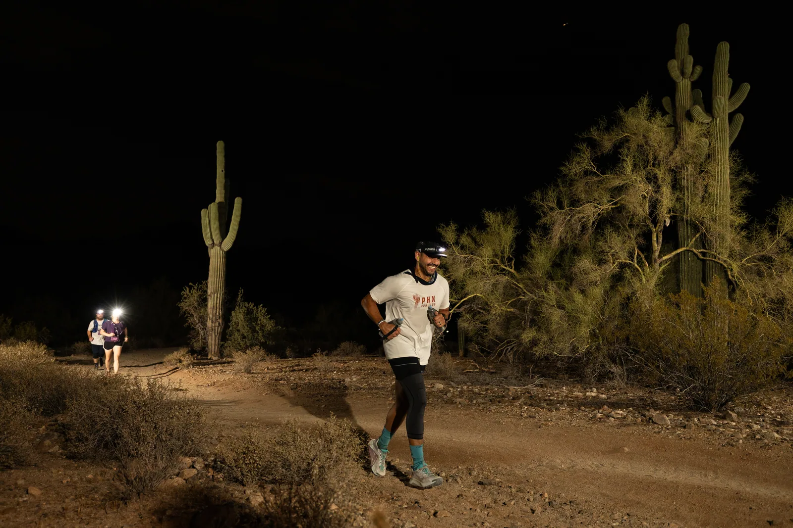 Runners among the saguaros at the Sinister Night Runs in San Tan Mountain Regional Park