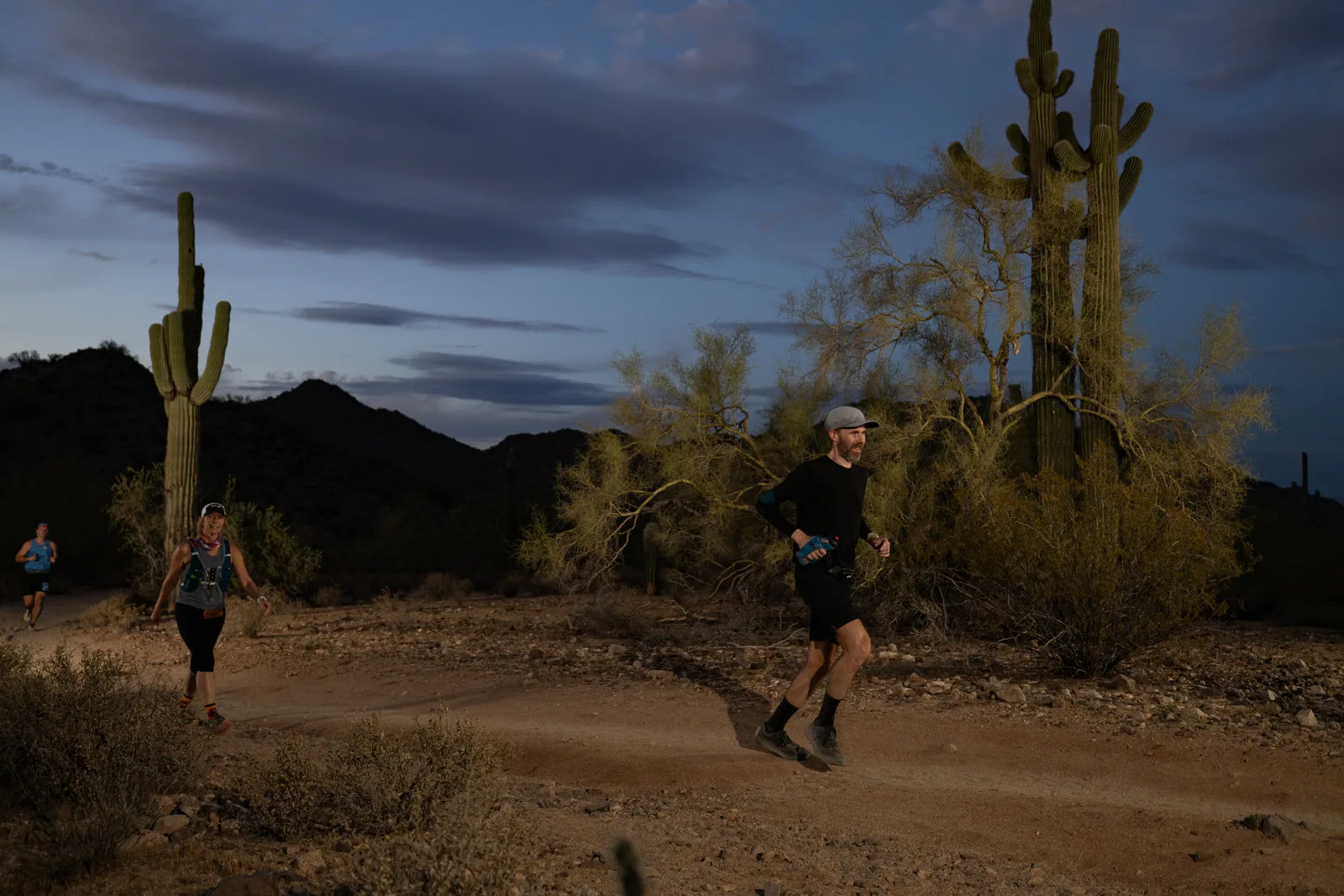 Runners among the saguaros at the Sinister Night Runs in San Tan Mountain Regional Park
