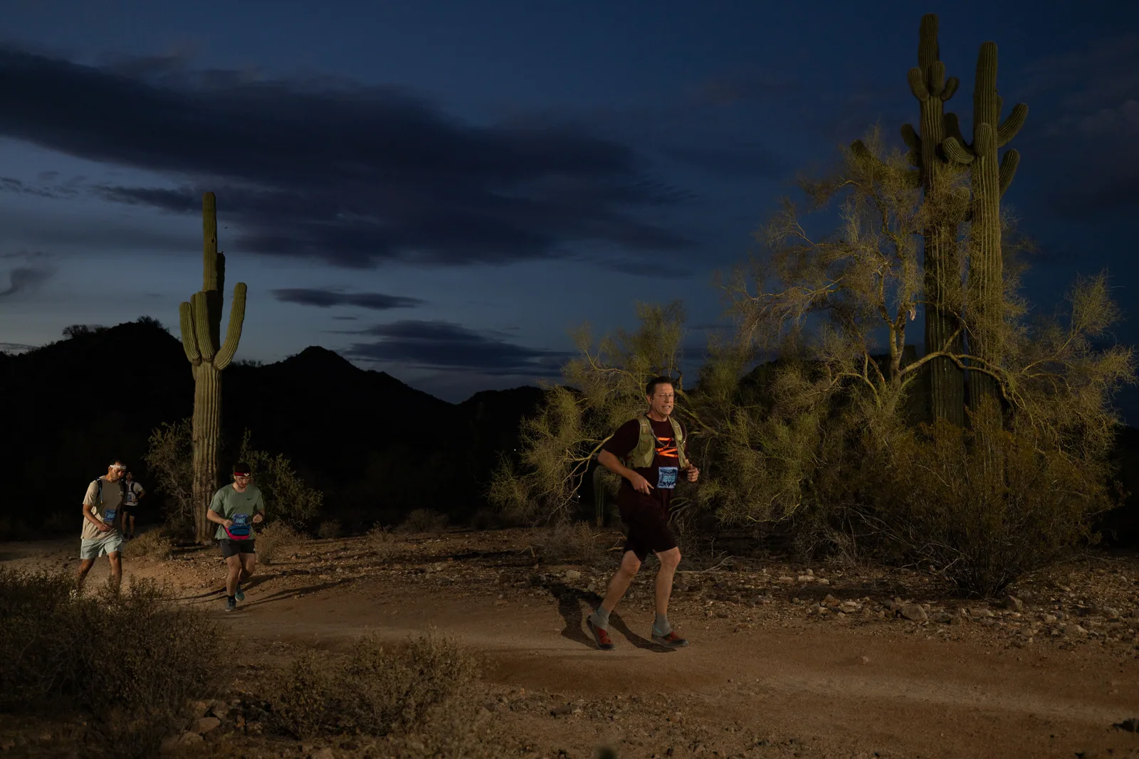 Runners among the saguaros at the Sinister Night Runs in San Tan Mountain Regional Park