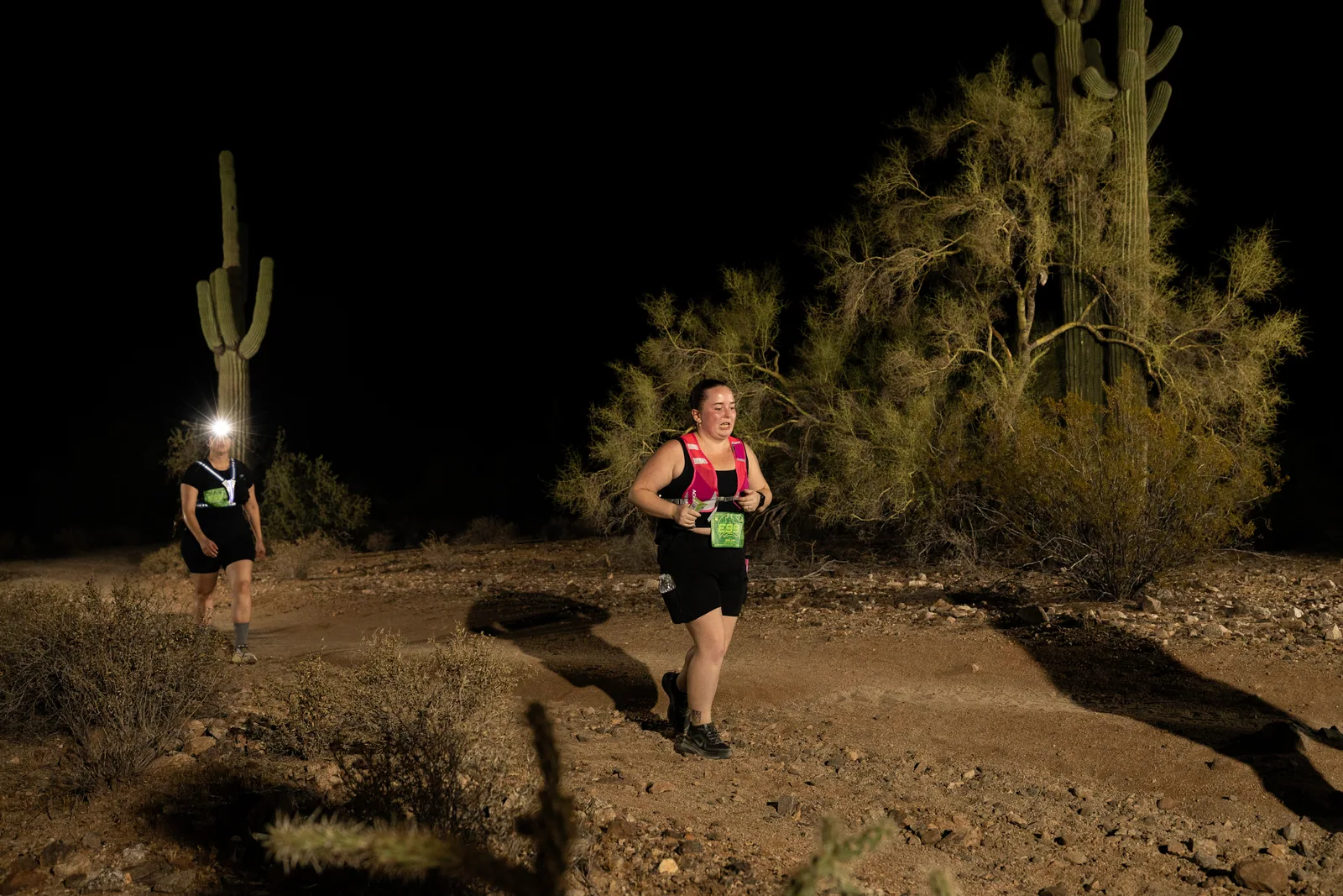 Runners among the saguaros at the Sinister Night Runs in San Tan Mountain Regional Park