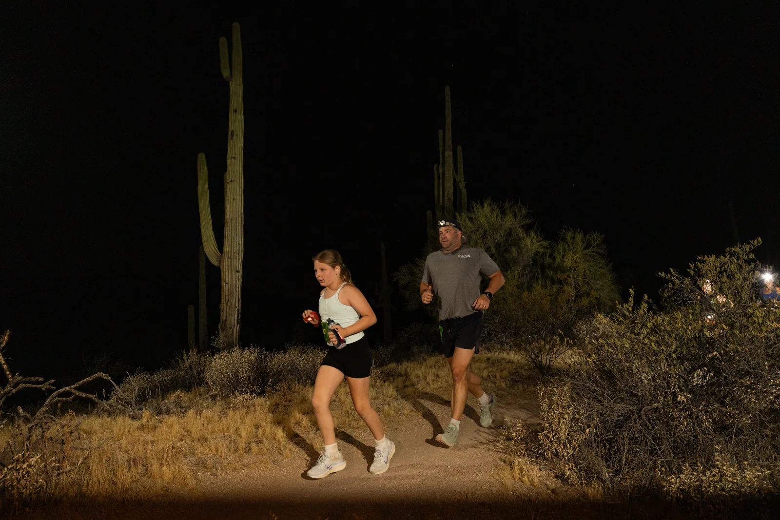 Runners by headlamp at the Adrenaline Night Runs in McDowell Mountain Regional Park