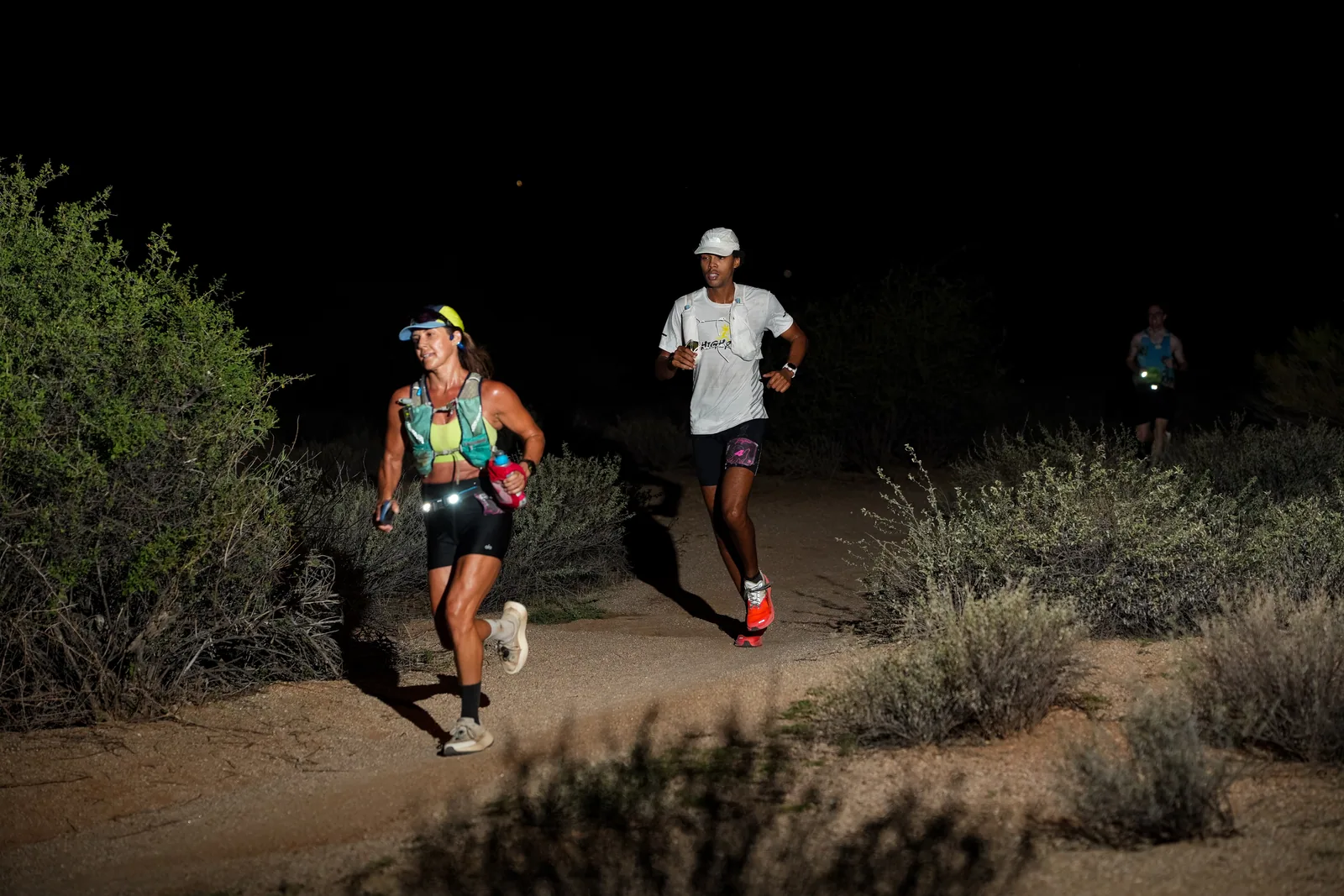 Runners at dusk and by headlamp at the Javelina Jangover Night Runs in McDowell Mountain Regional Park