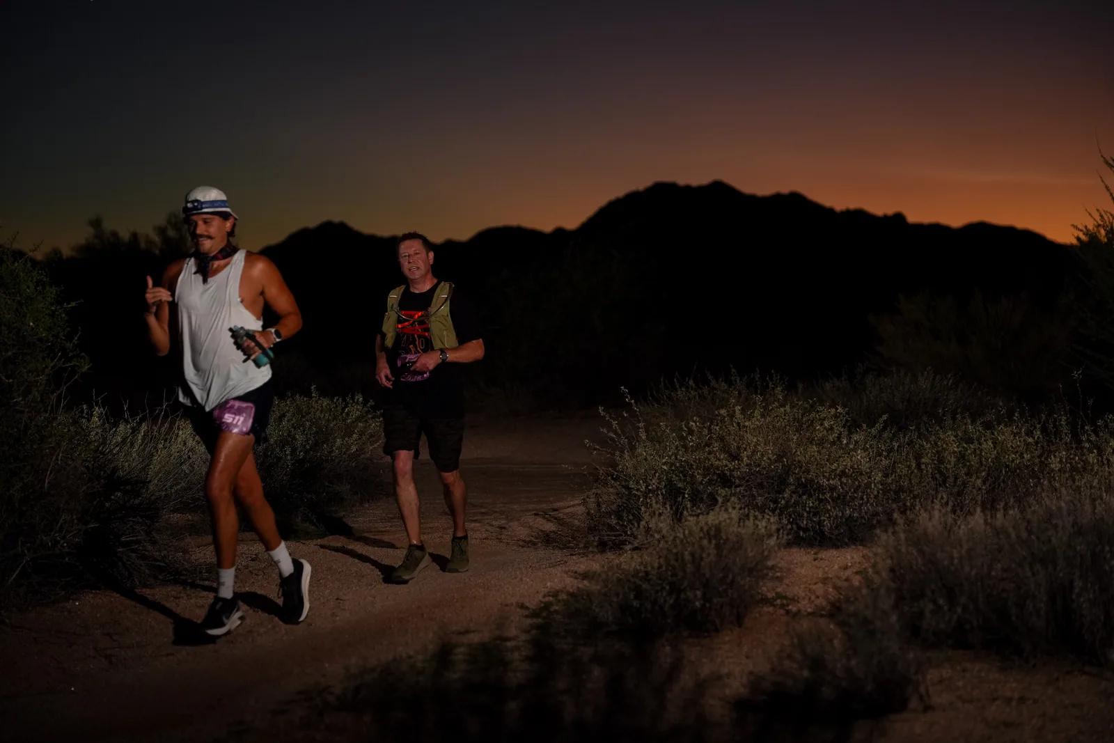 Runners at dusk and by headlamp at the Javelina Jangover Night Runs in McDowell Mountain Regional Park