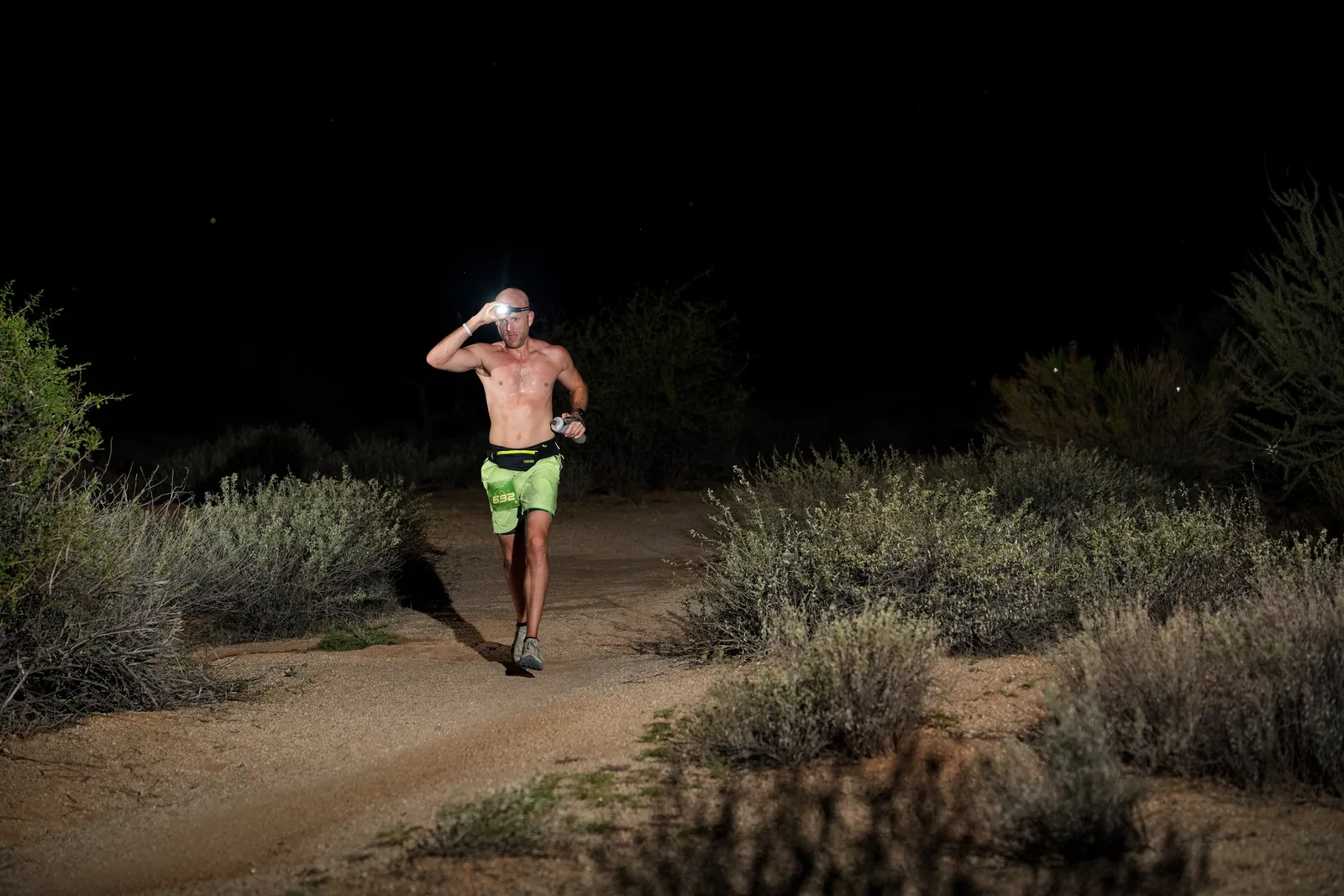 Runners at dusk and by headlamp at the Javelina Jangover Night Runs in McDowell Mountain Regional Park
