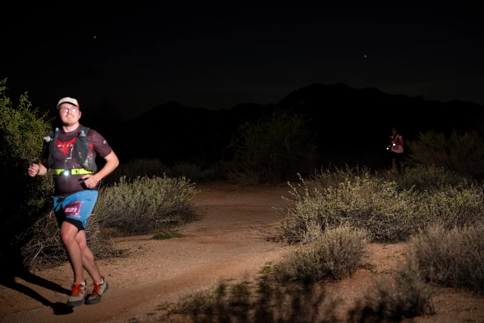 Runners at dusk and by headlamp at the Javelina Jangover Night Runs in McDowell Mountain Regional Park