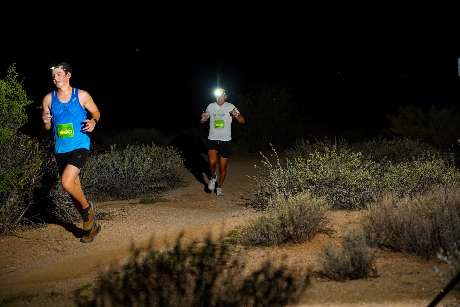 Runners at dusk and by headlamp at the Javelina Jangover Night Runs in McDowell Mountain Regional Park