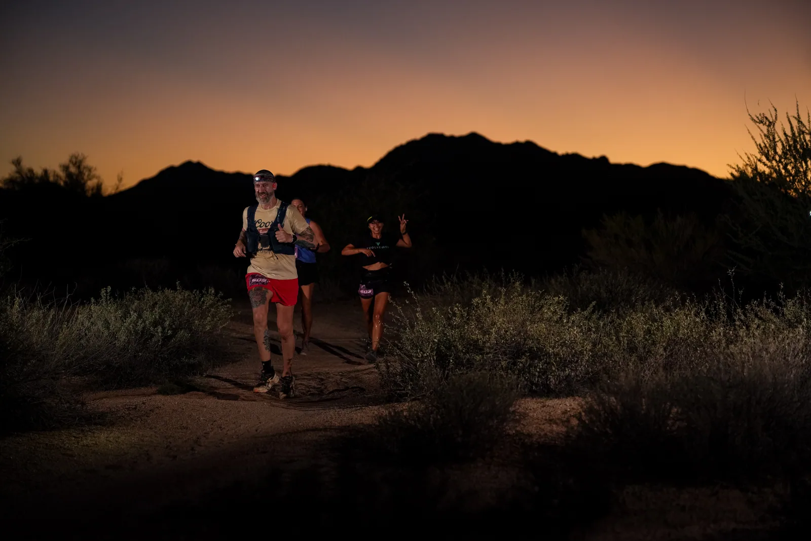 Runners at dusk and by headlamp at the Javelina Jangover Night Runs in McDowell Mountain Regional Park