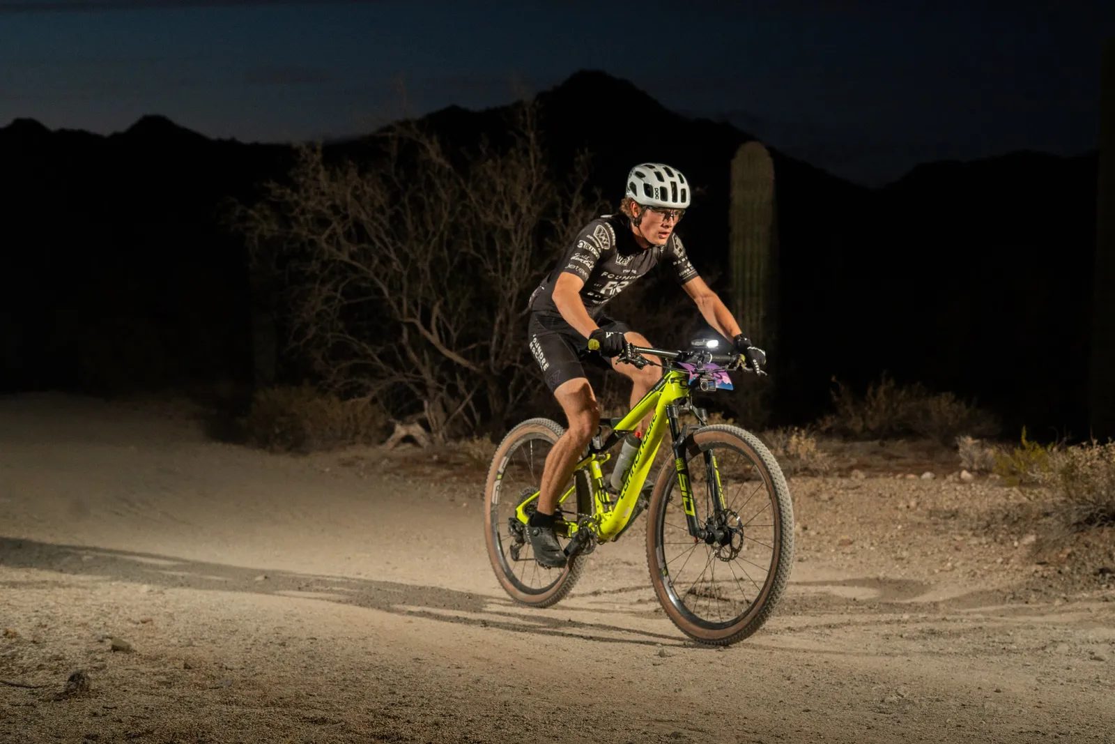 Rider by bike light among the saguaros at the Sinister Night Rides in San Tan Mountain Regional Park