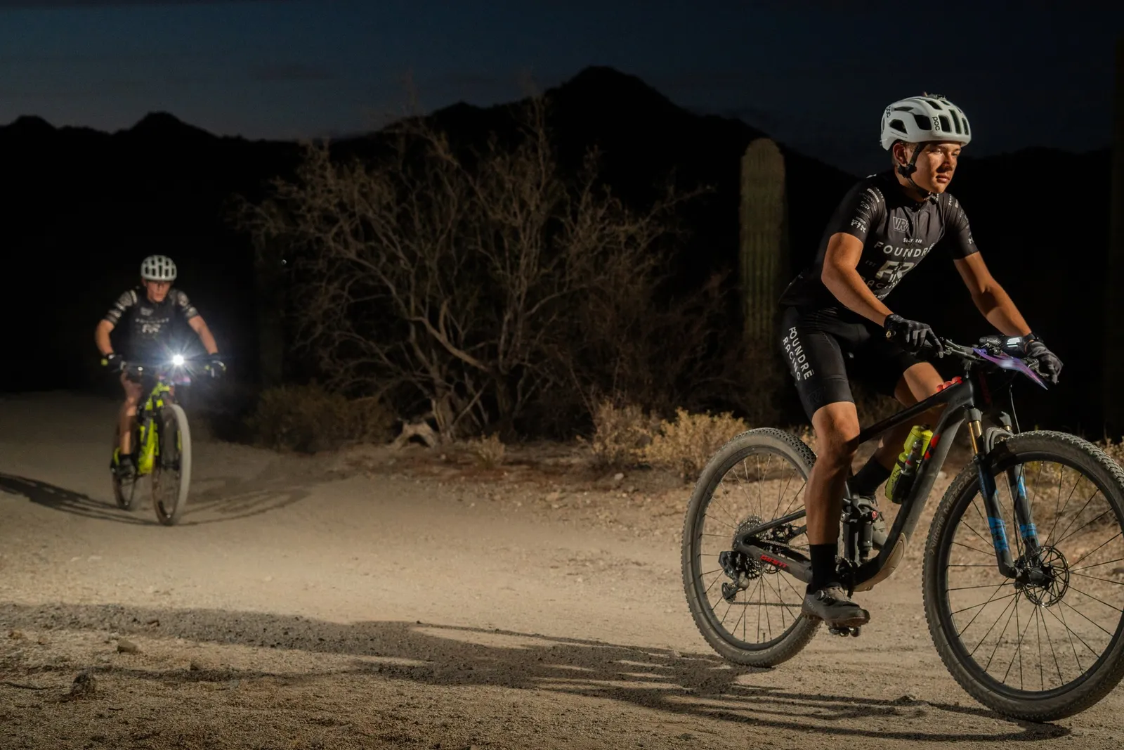 Rider by bike light among the saguaros at the Sinister Night Rides in San Tan Mountain Regional Park