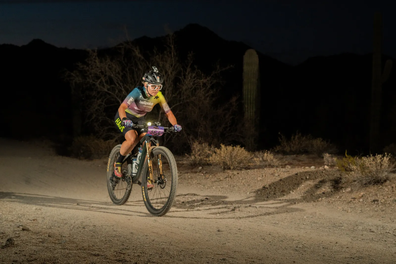 Rider by bike light among the saguaros at the Sinister Night Rides in San Tan Mountain Regional Park