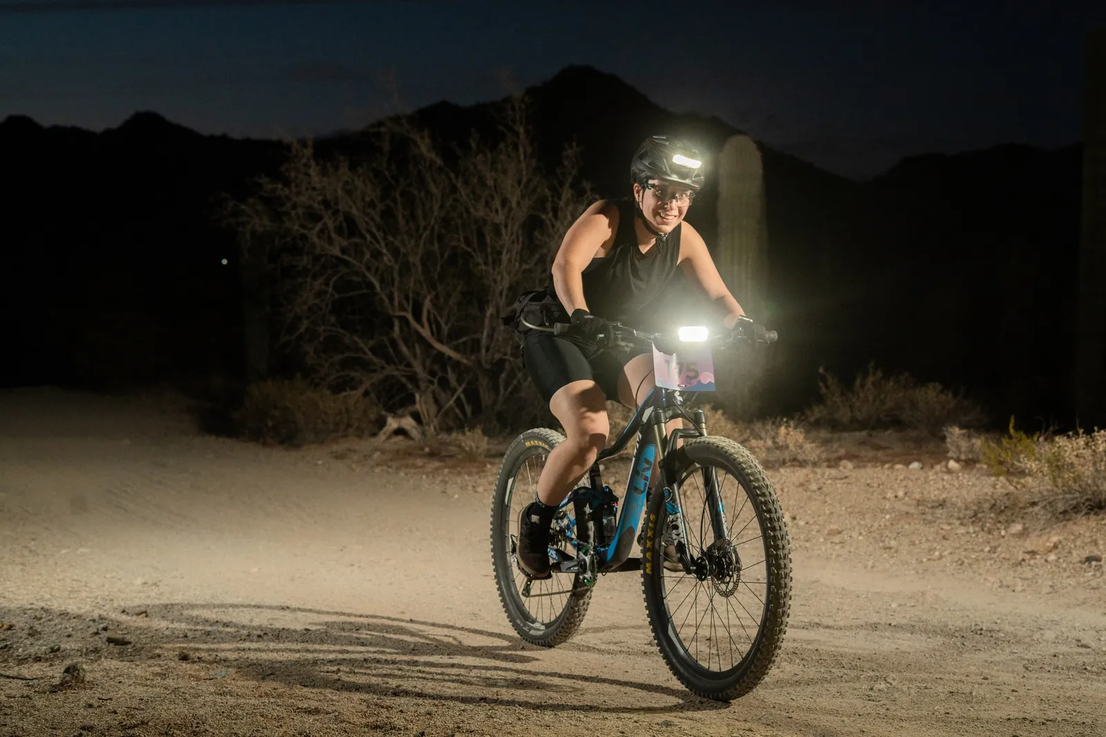 Rider by bike light among the saguaros at the Sinister Night Rides in San Tan Mountain Regional Park