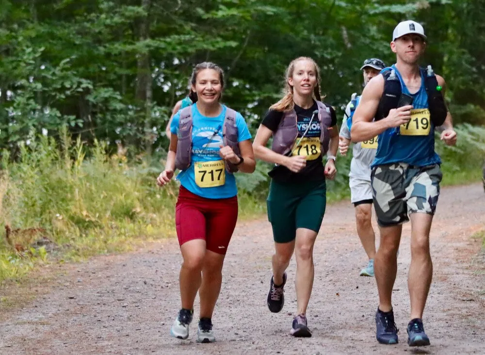 Three runners side by side on the trail