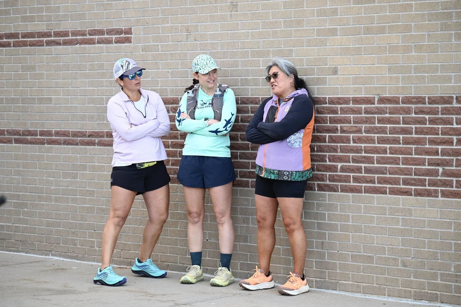 Three runners waiting by the school wall before the race
