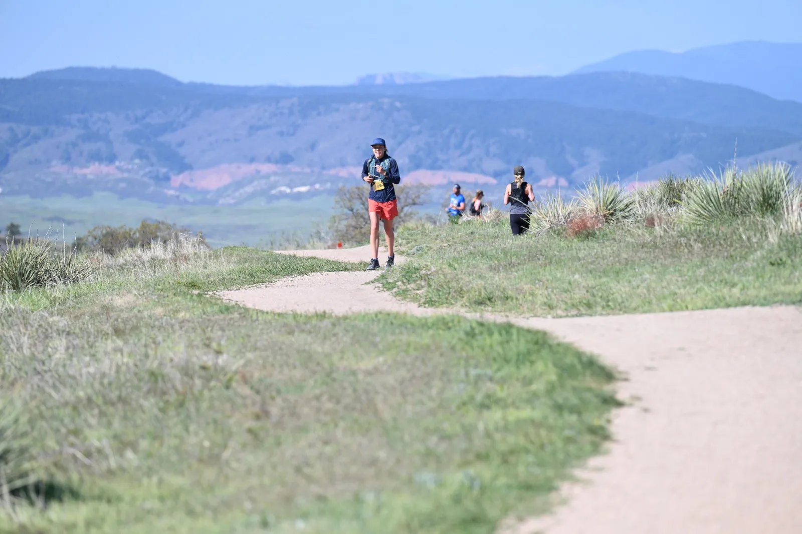 Runners on the winding trail below the mountains