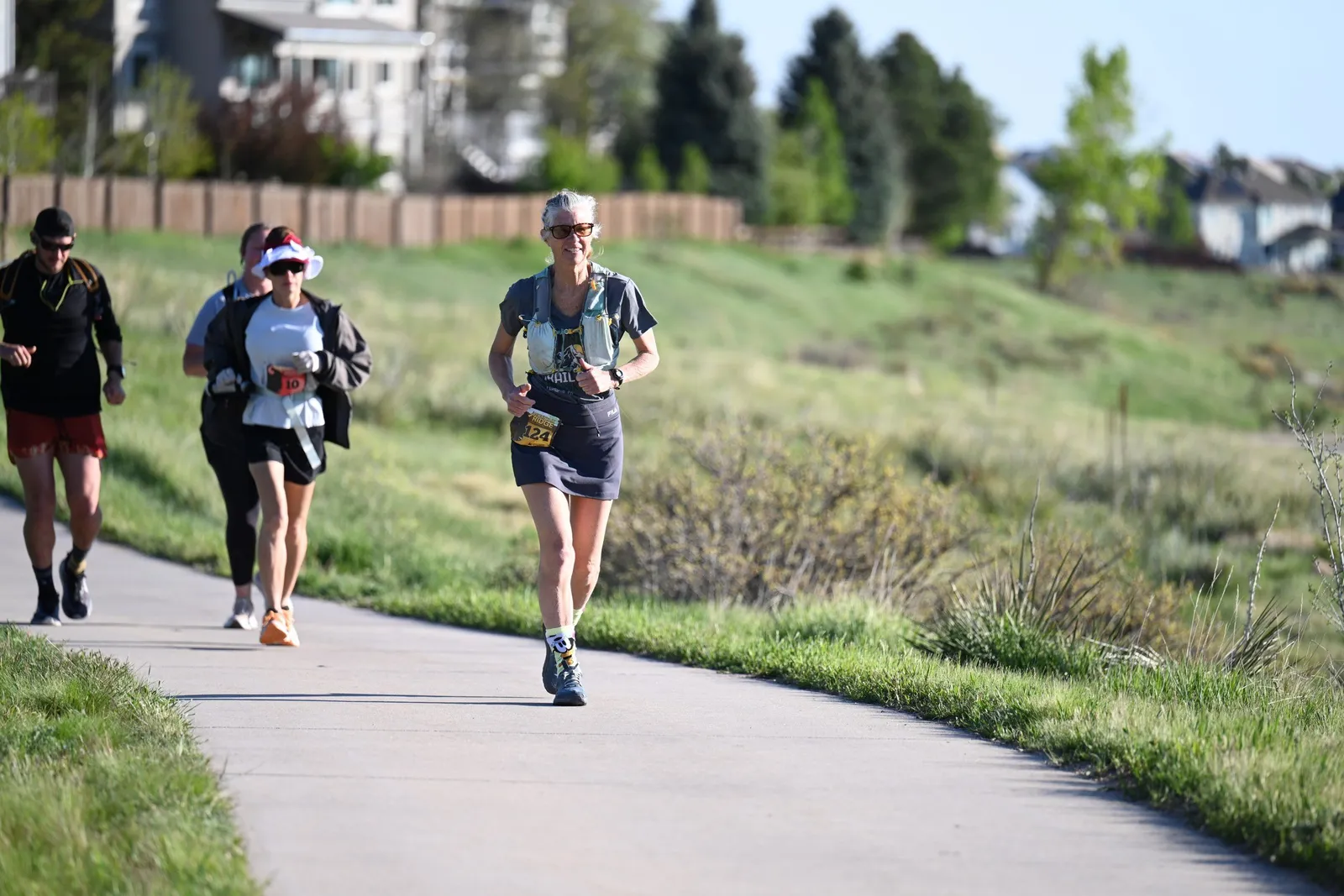 Runners on the trail through green grass