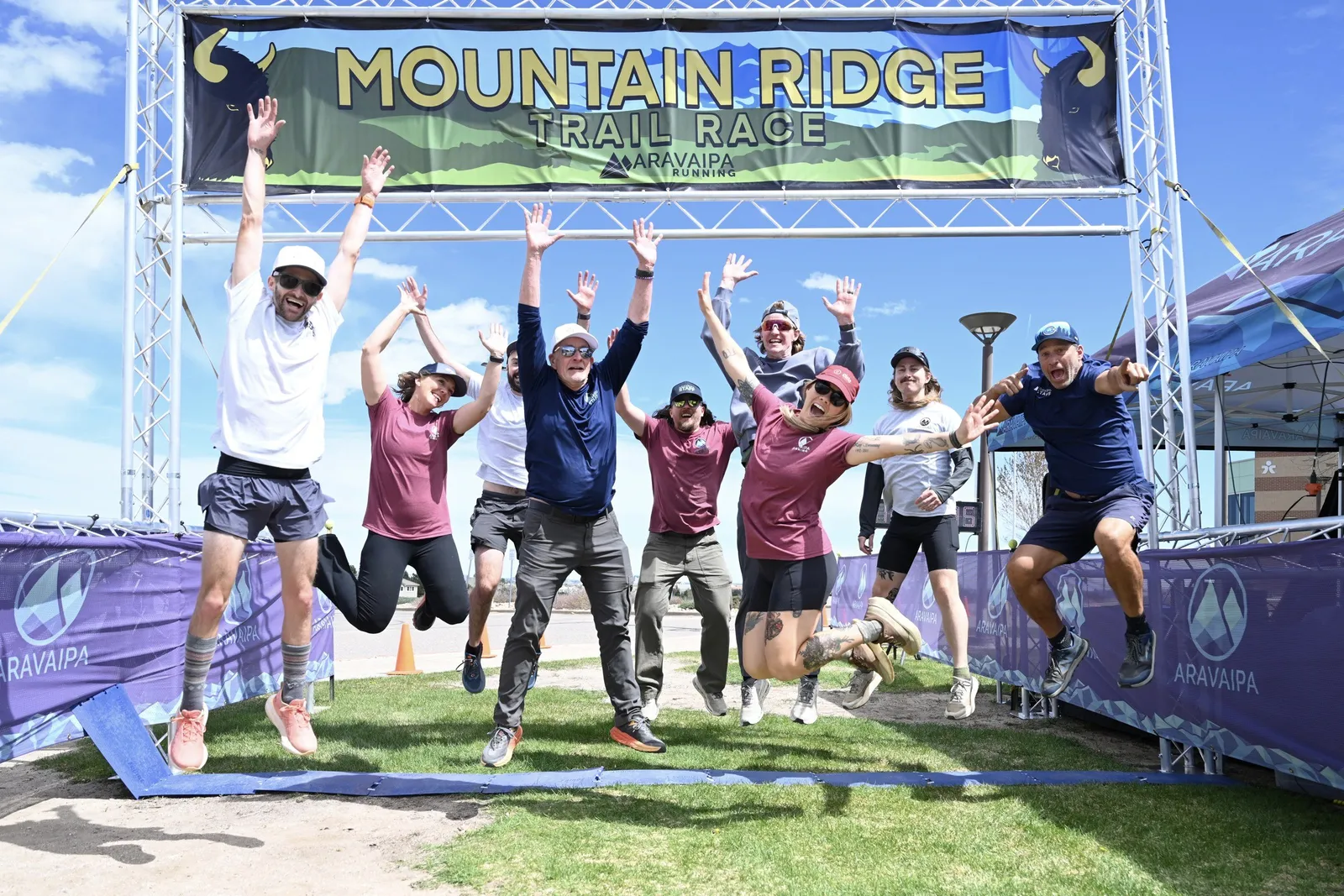 A group jumping under the Mountain Ridge arch