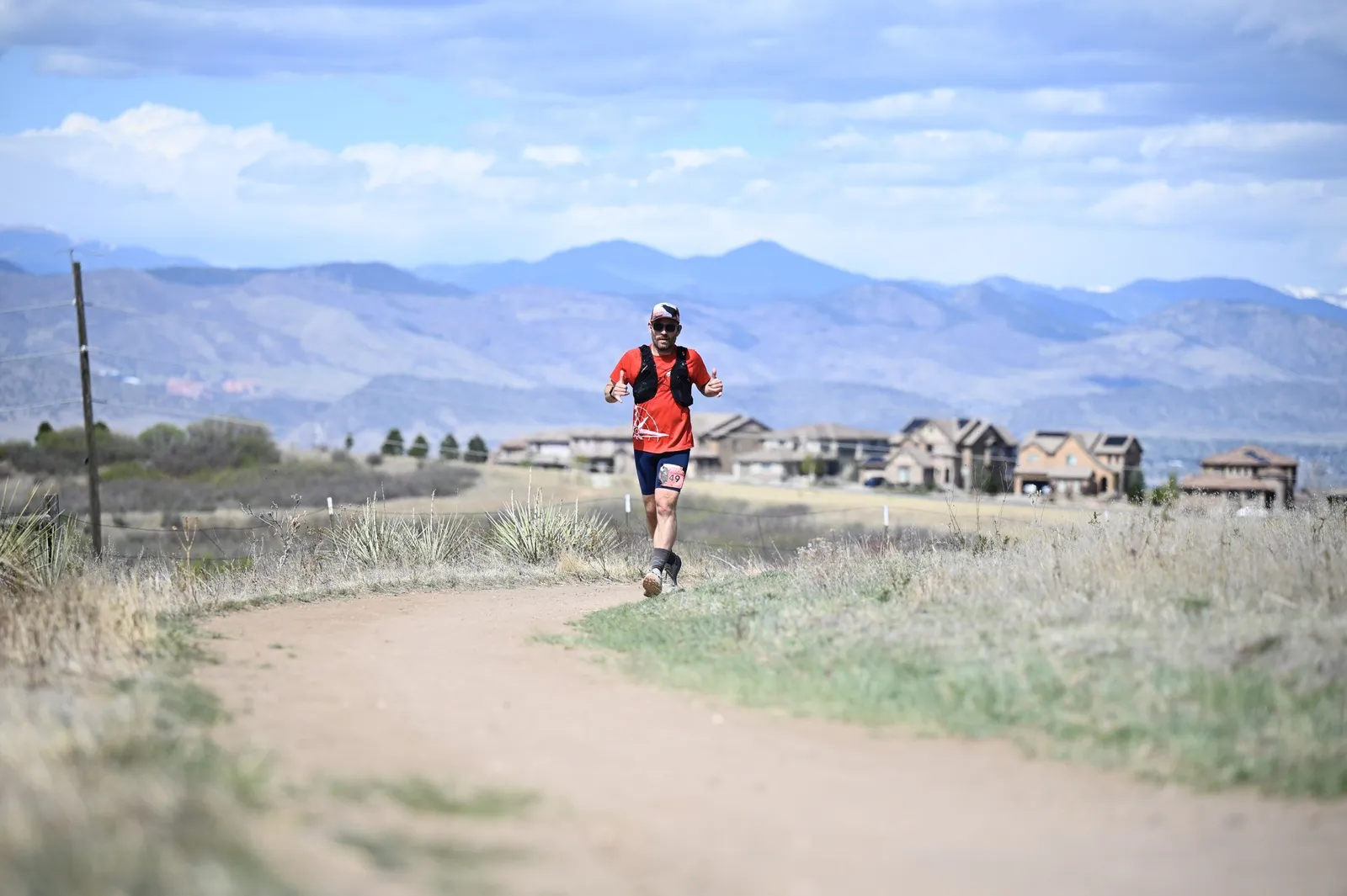 A runner alone on the trail with the Front Range behind