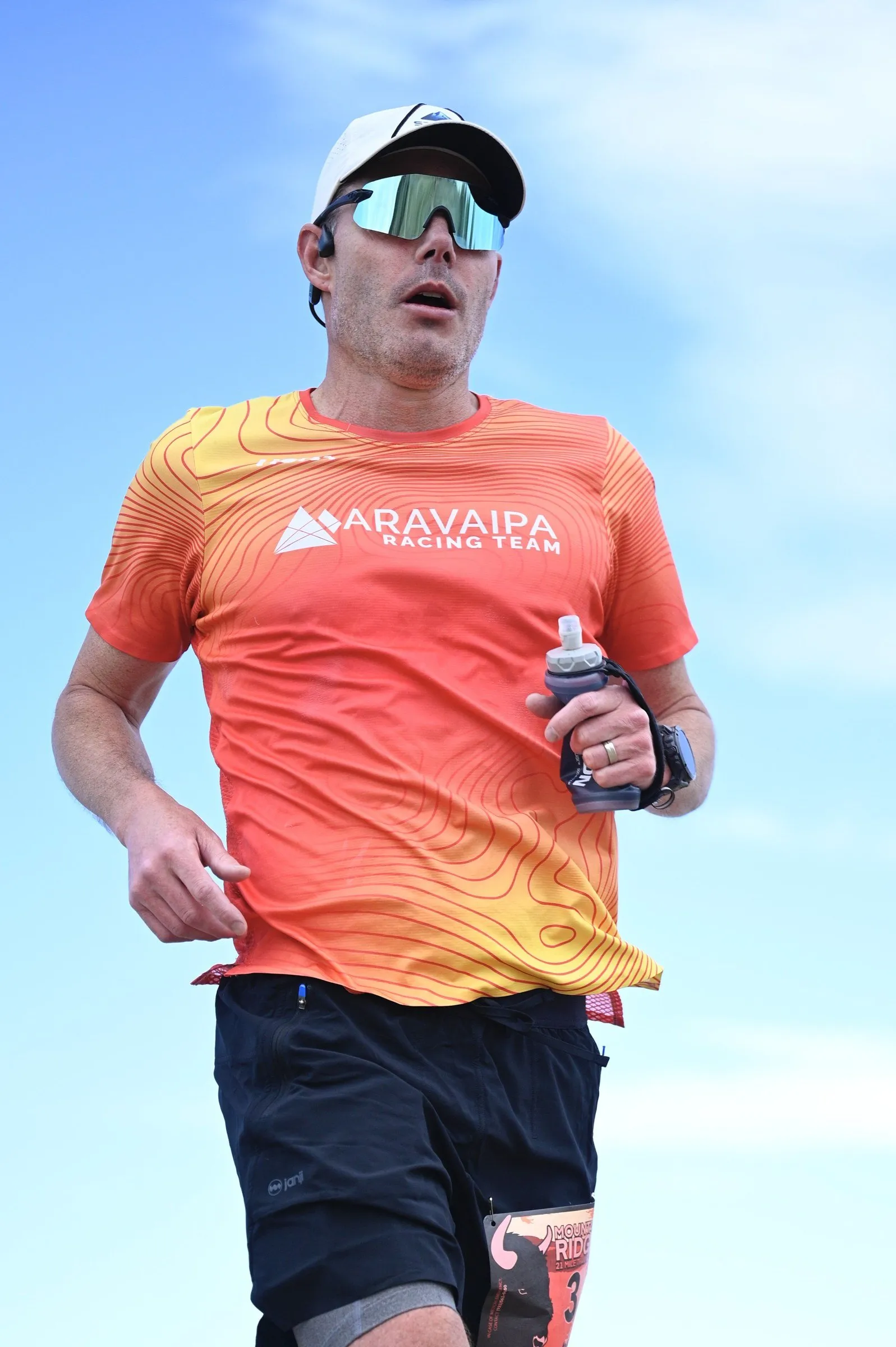 A runner in orange charging toward the camera