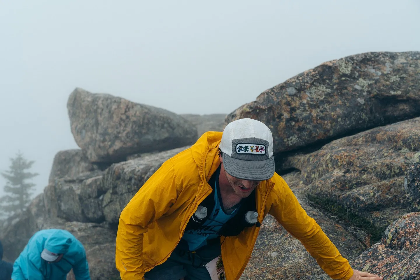 Runner in a yellow jacket climbing the summit block