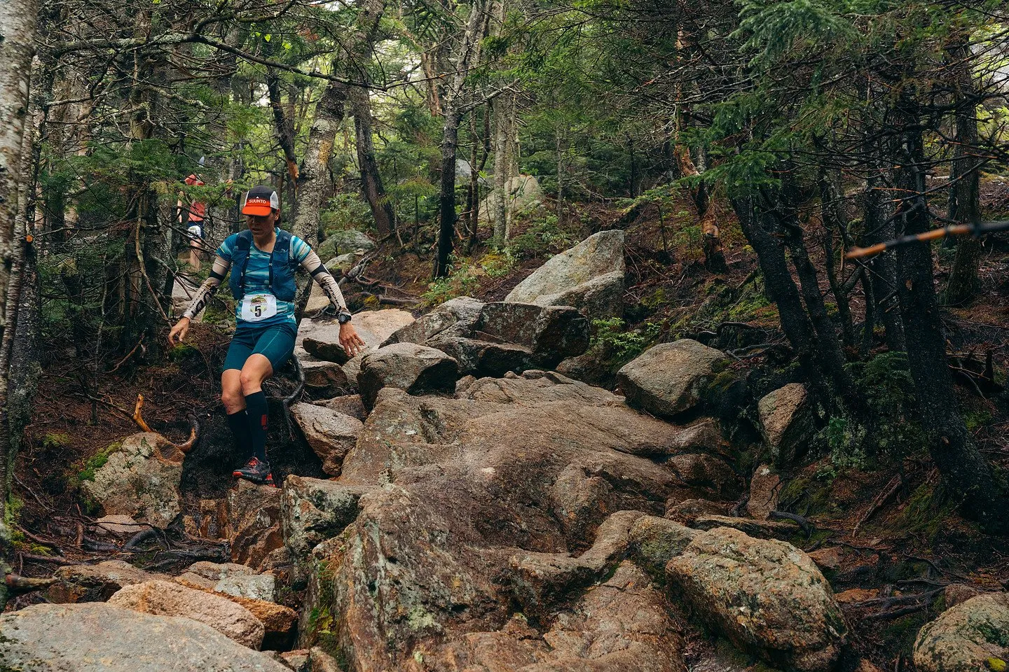 Runner hopping down a boulder field