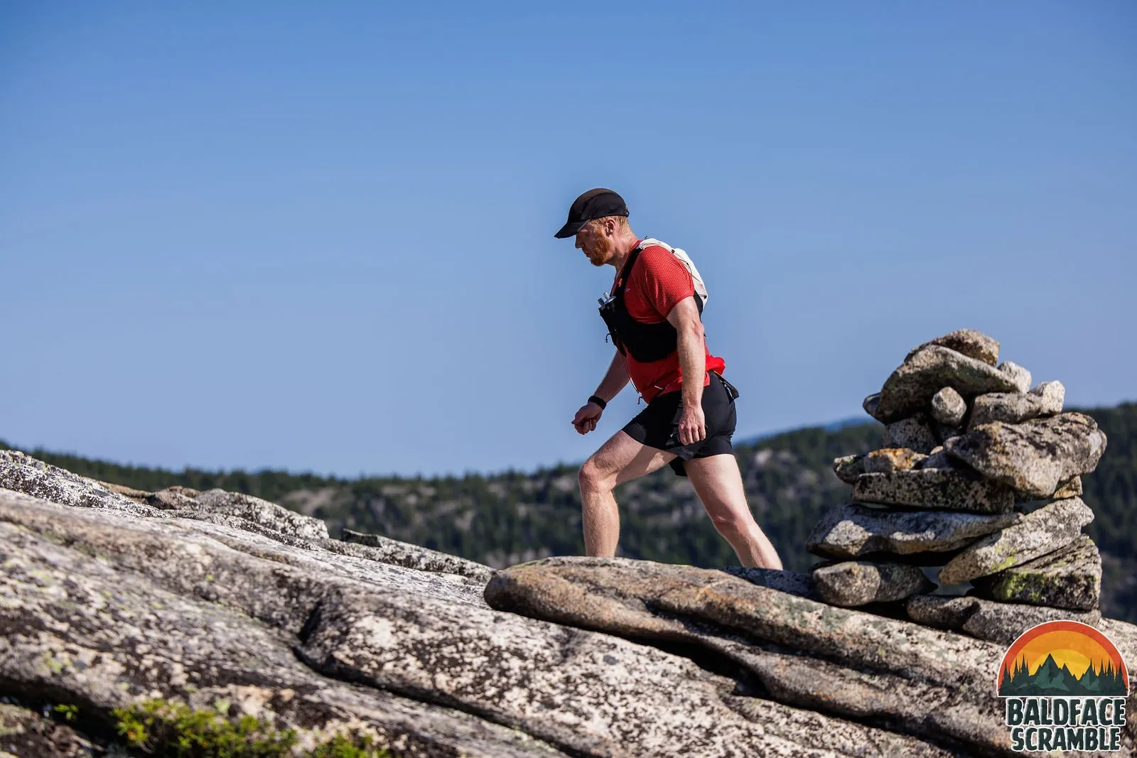 Runner passing a cairn on the summit