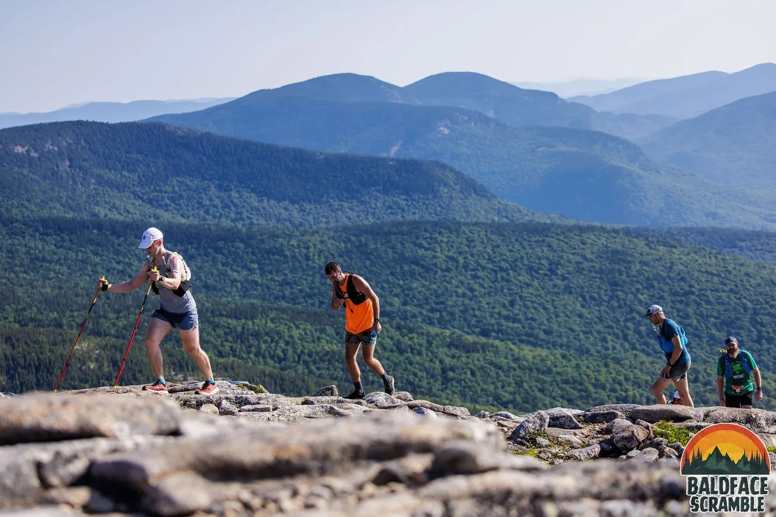 Runners crossing the open ledges with the White Mountains behind