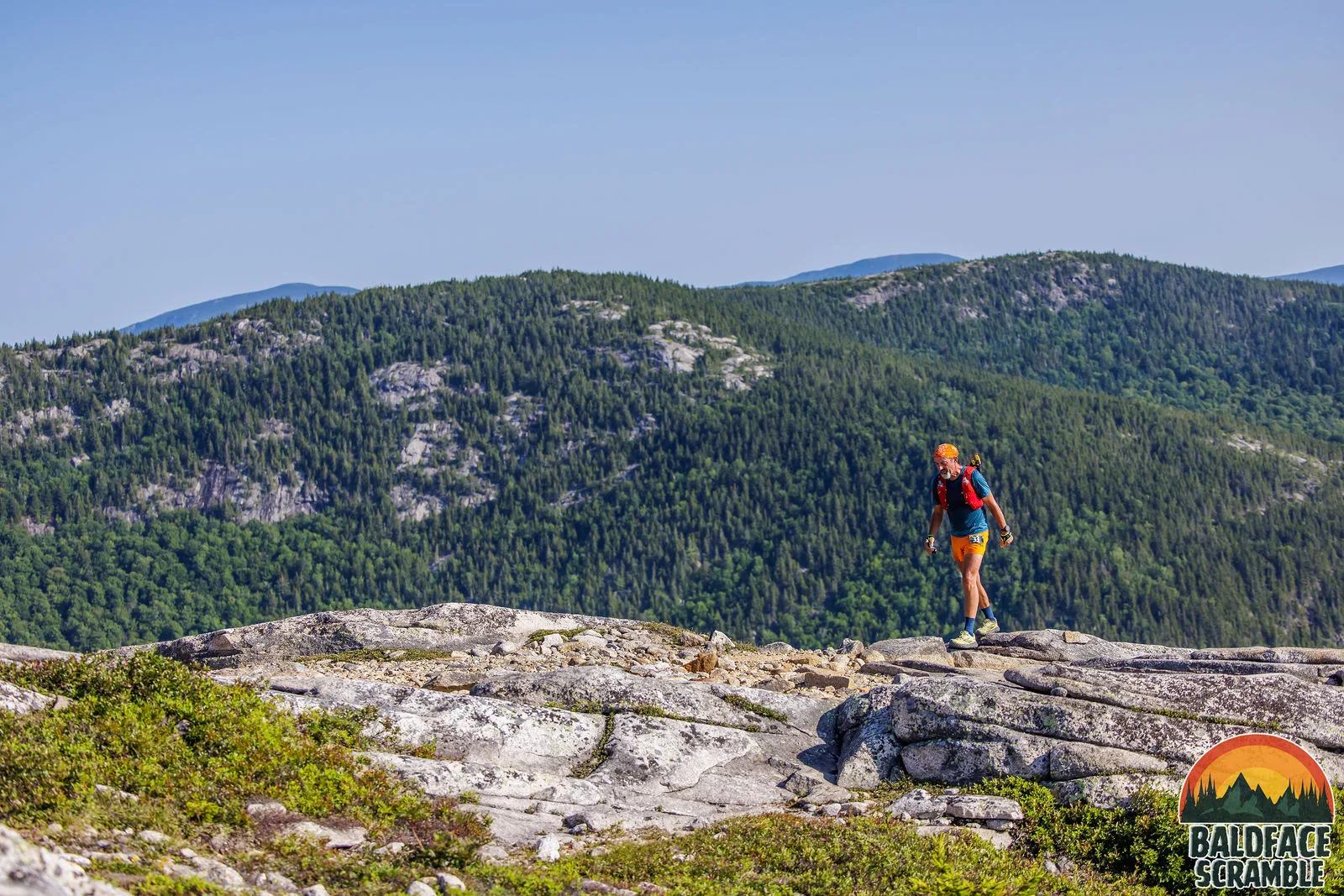 A runner on the ledges with the Evans Notch hills behind