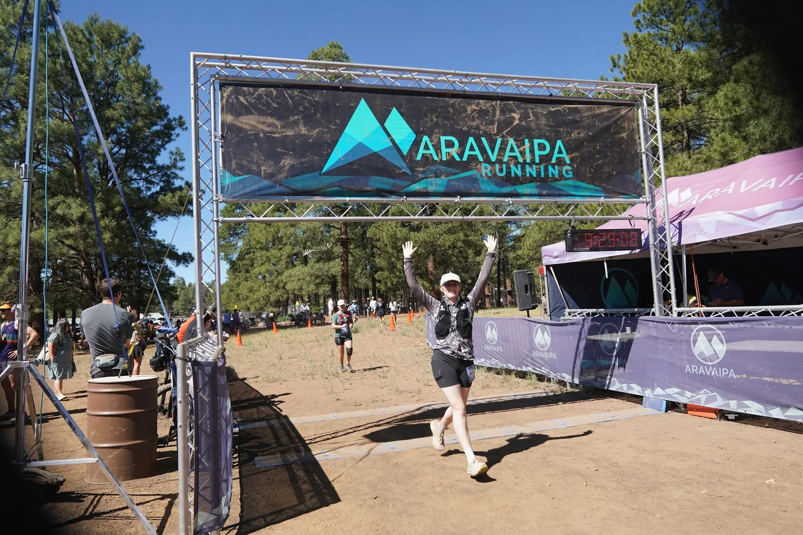 A runner celebrating at the Big Pine Trail Runs finish line in the Flagstaff ponderosa pines
