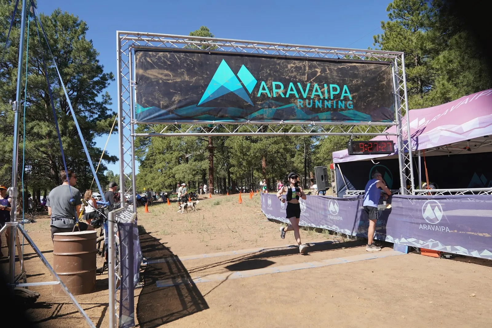 A runner crossing the Big Pine Trail Runs finish line in the Flagstaff ponderosa pines