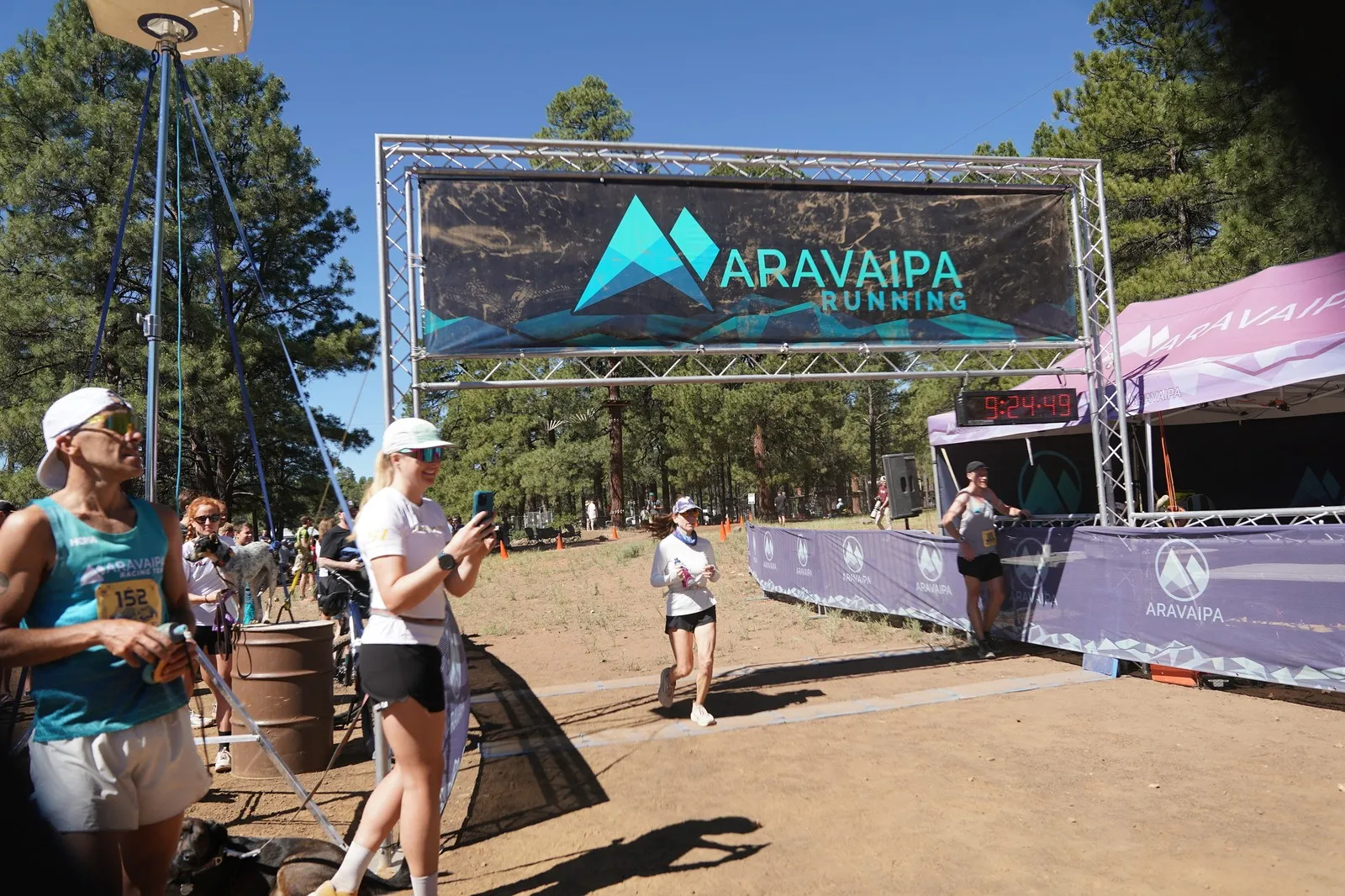 A runner jogging in at the Big Pine Trail Runs finish line in the Flagstaff ponderosa pines