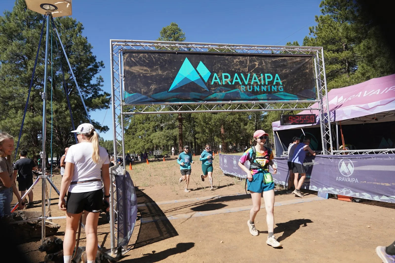 A runner in a pink hat at the Big Pine Trail Runs finish line in the Flagstaff ponderosa pines