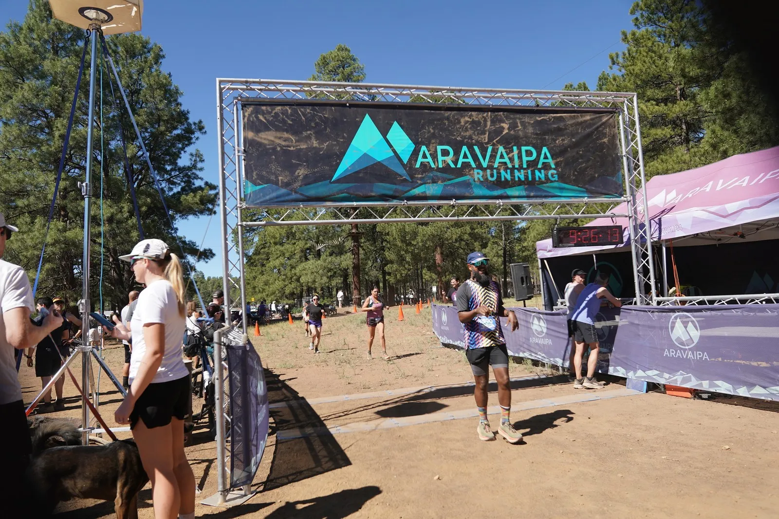 A runner finishing at the Big Pine Trail Runs finish line in the Flagstaff ponderosa pines