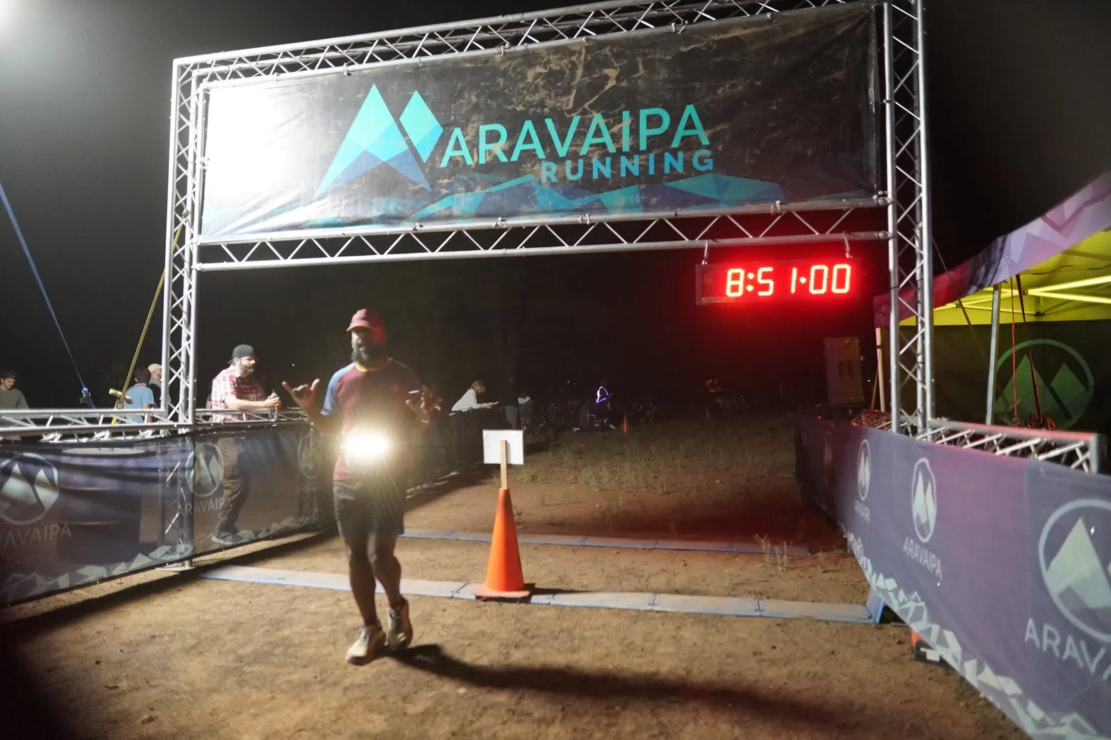 A runner with a waist light at the Blackout Night Runs finish line in the Flagstaff pines