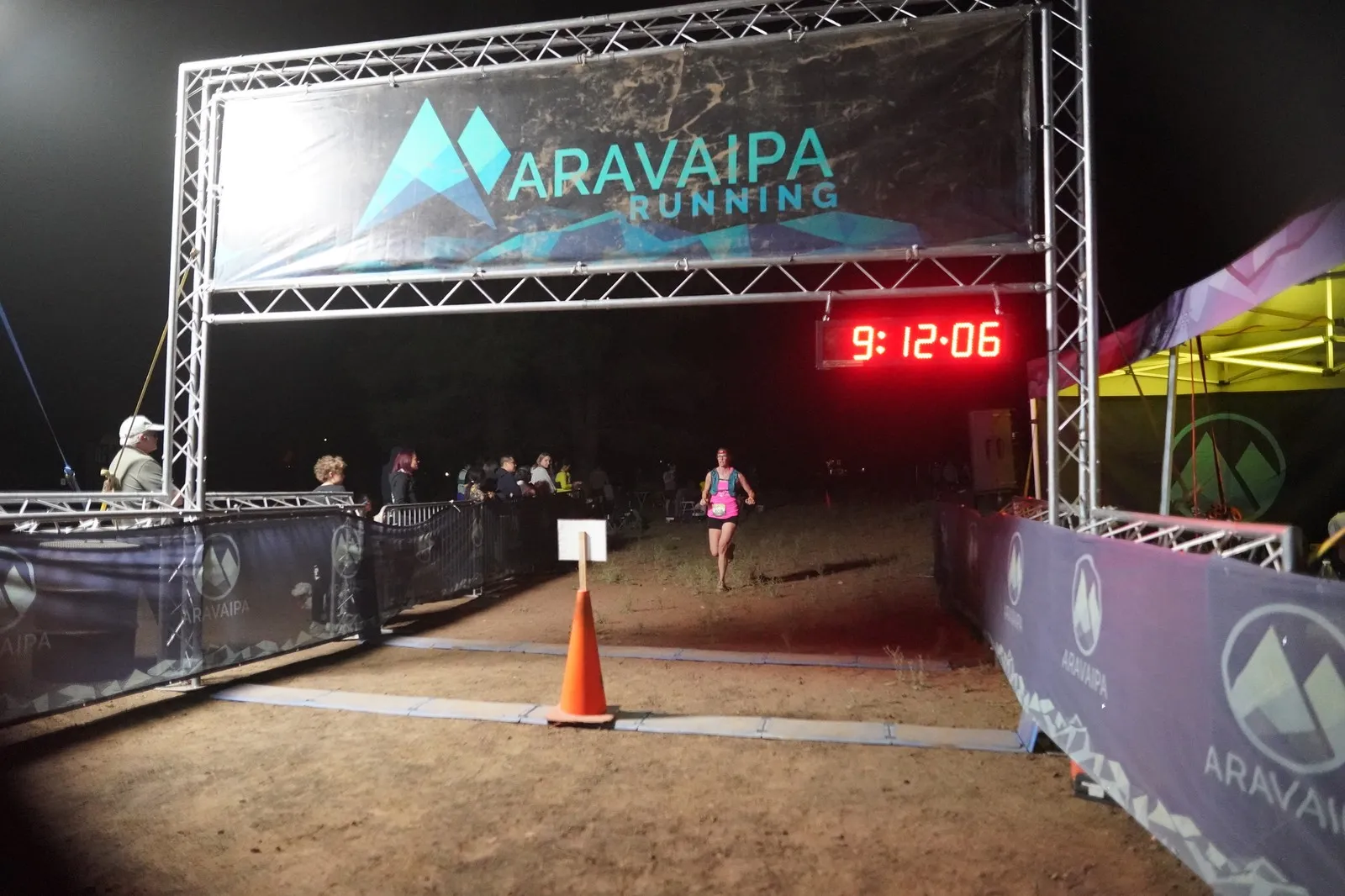 A runner in pink at the Blackout Night Runs finish line in the Flagstaff pines