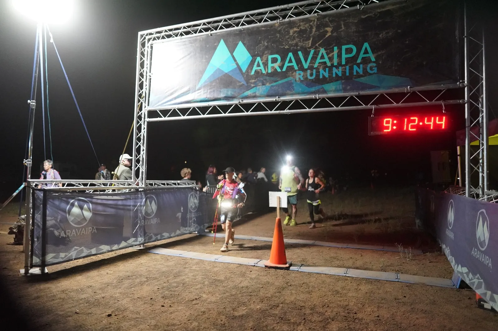 Runners with headlamps at the Blackout Night Runs finish line in the Flagstaff pines