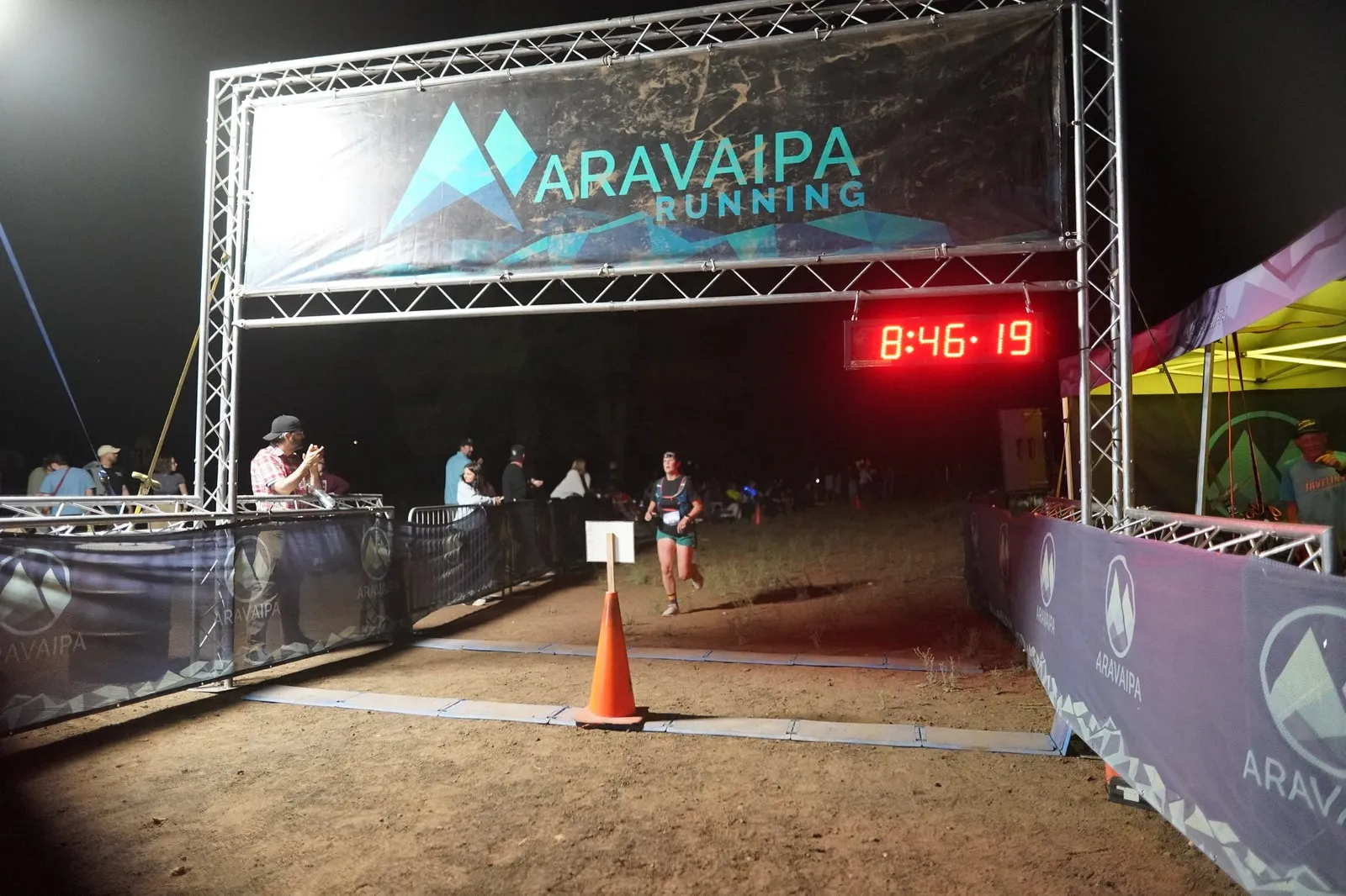 A runner on the final stretch at the Blackout Night Runs finish line in the Flagstaff pines