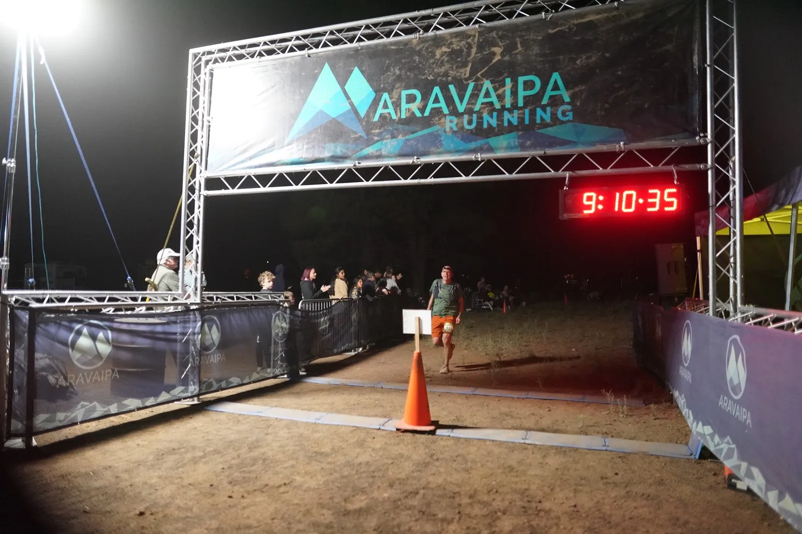 A runner coming in to the Blackout Night Runs finish line in the Flagstaff pines