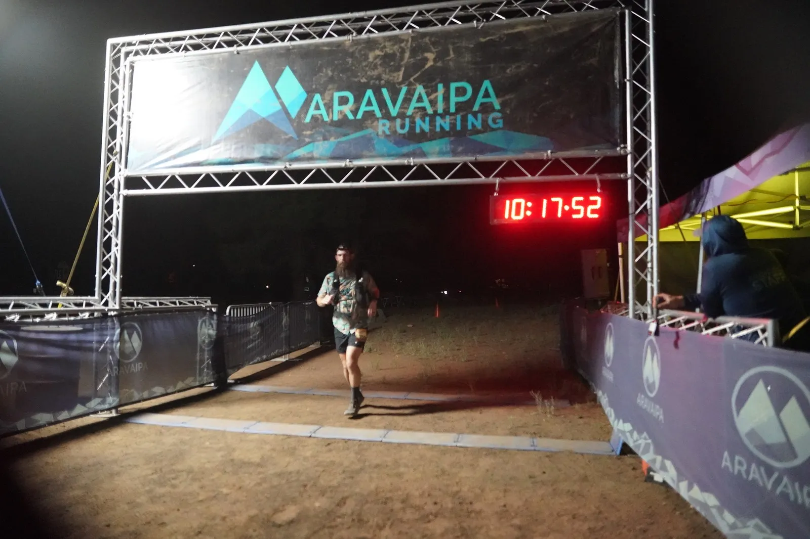 A runner in a vest at the Blackout Night Runs finish line in the Flagstaff pines