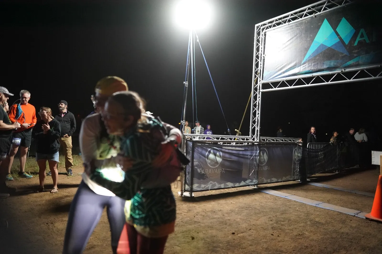 Finishers hugging at the Blackout Night Runs finish line in the Flagstaff pines