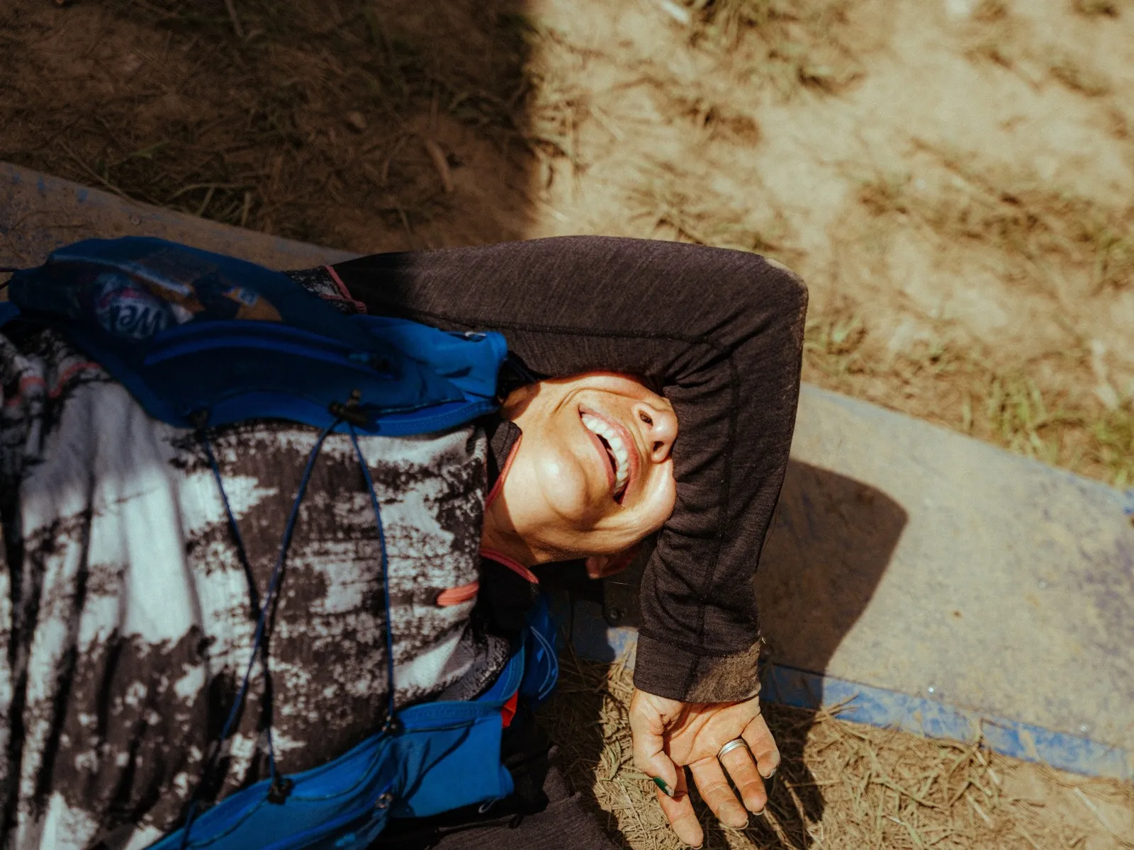 A finisher lies on the ground laughing after crossing the line