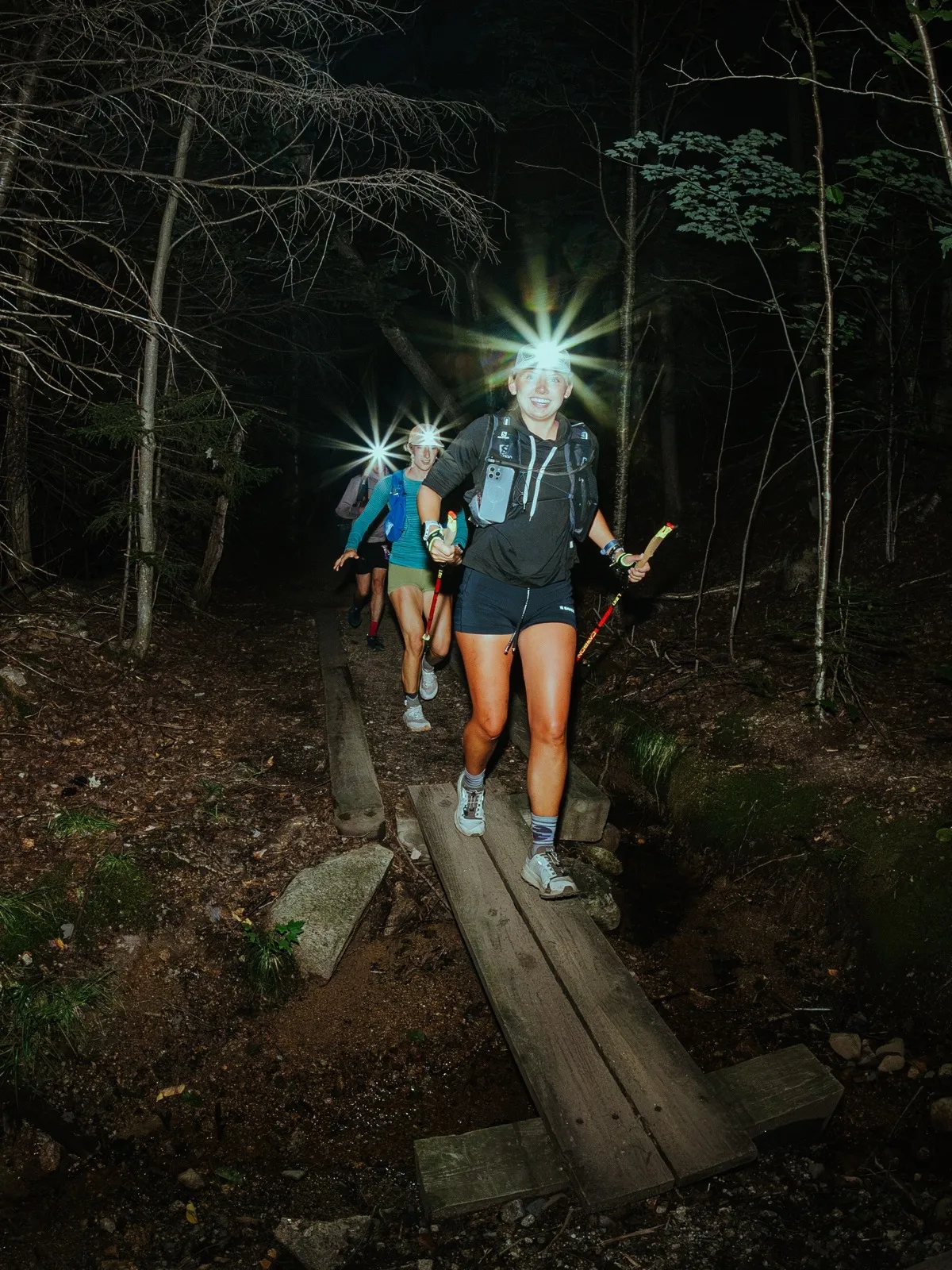 Headlamps blaze along the boardwalk deep in the night woods