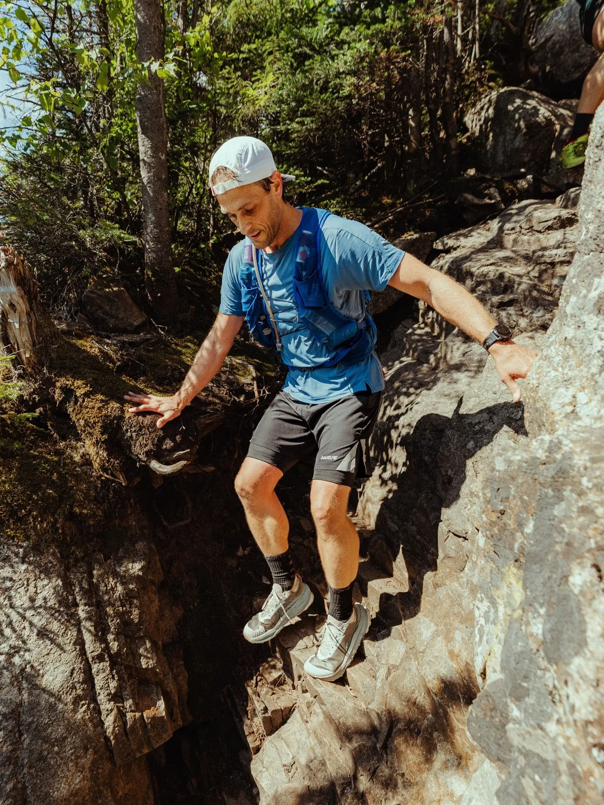 A runner down climbs a granite chute on the steep ledges