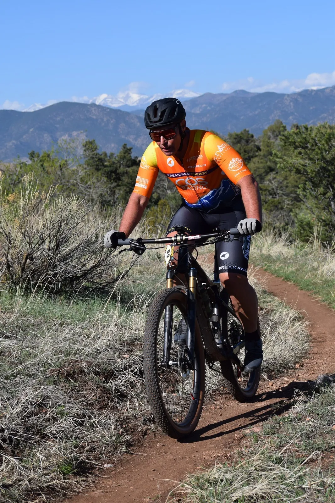 A rider in orange on the singletrack at Royal Gorge Groove Rides