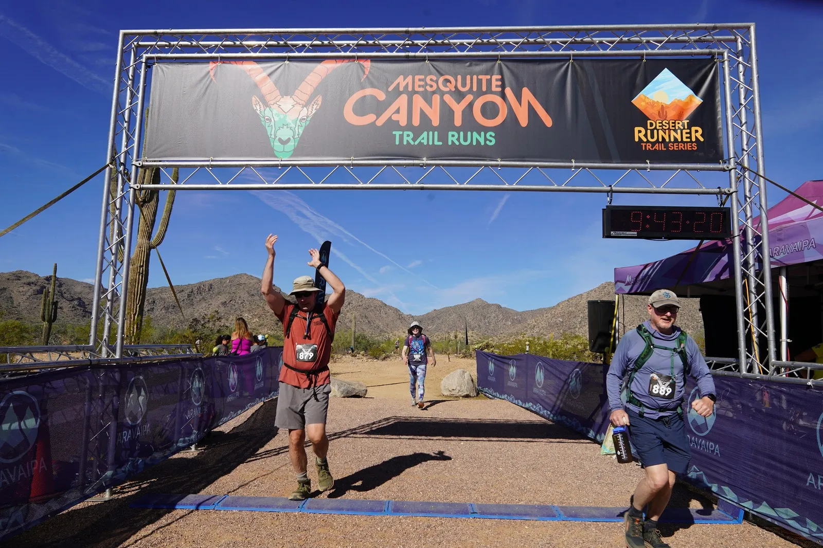 Runners cheering at the Mesquite Canyon Trail Runs finish line, a Sonoran Desert Cup race in White Tank Mountain Regional Park